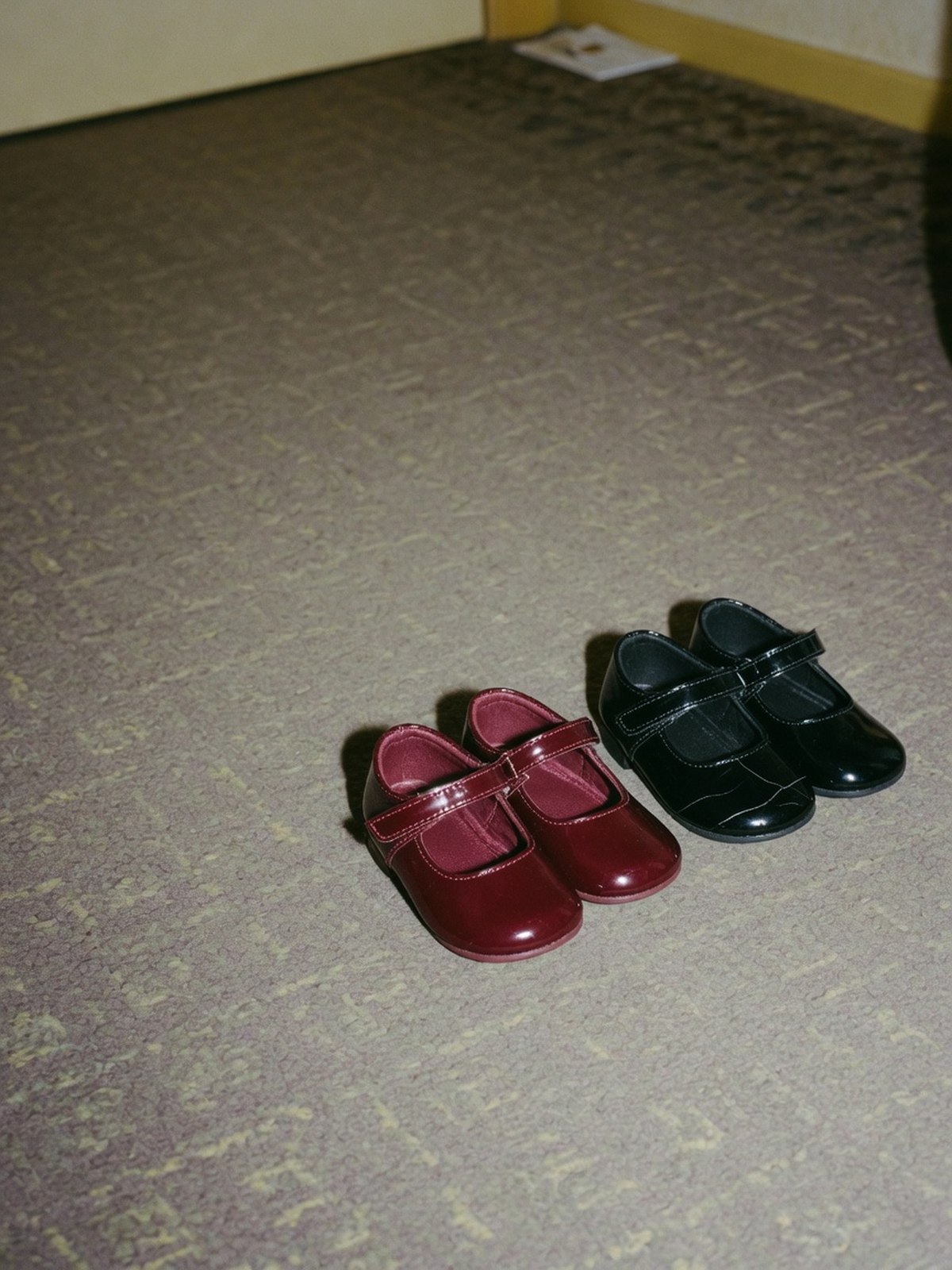 Comparaison en gros plan de deux babies vernies, l'une en cuir souple, l'autre en synthétique marqué d'une craquelure au pli.