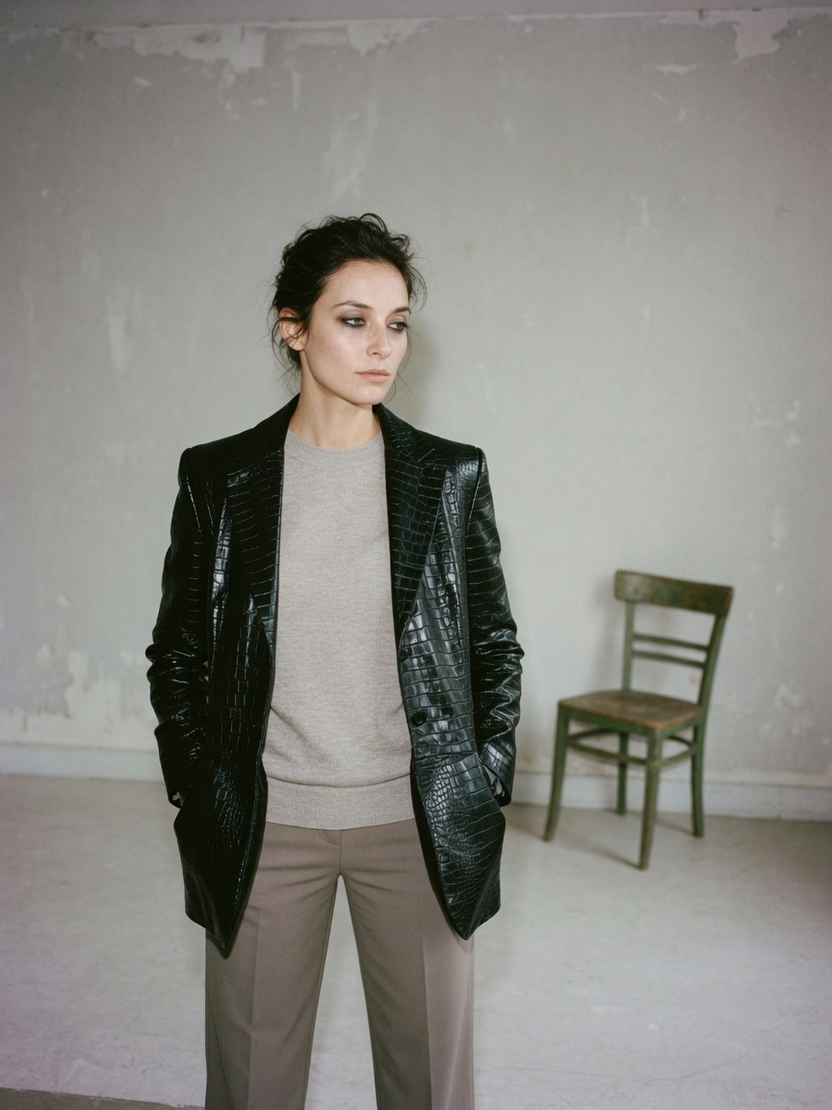 Silhouette montrant une veste effet crocodile portée sur un pull fin et un pantalon droit, seule pièce en cuir de la tenue.