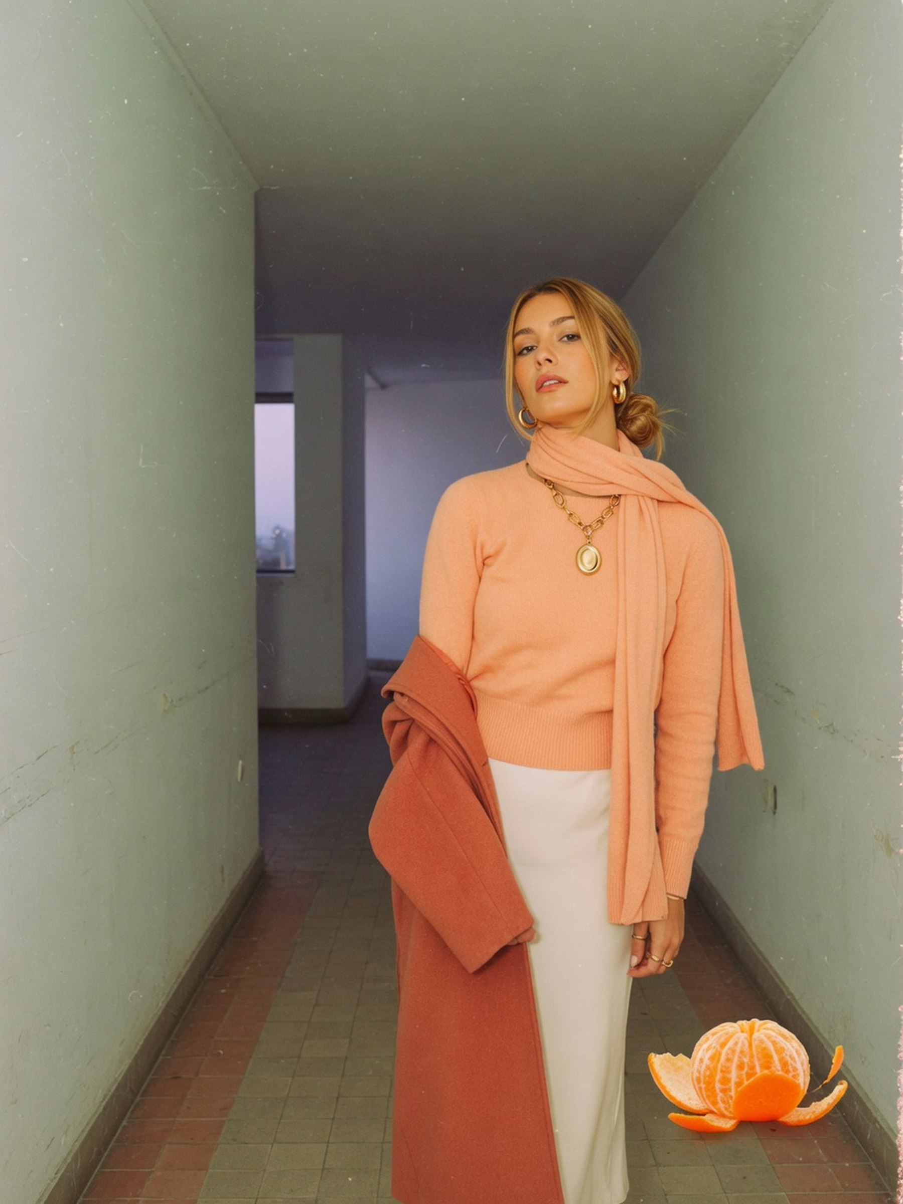 Mannequin en manteau terracotta et bijoux dorés, palette automne-hiver 2026-2027 adaptée à une colorimétrie printemps.