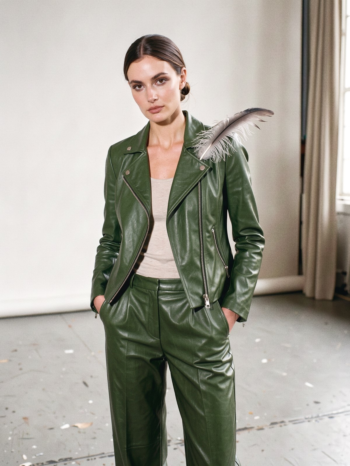 Mannequin portant un tailleur pantalon en nappa vert forêt ultra-fin qui tombe comme un tissu, sur une scène de théâtre vide