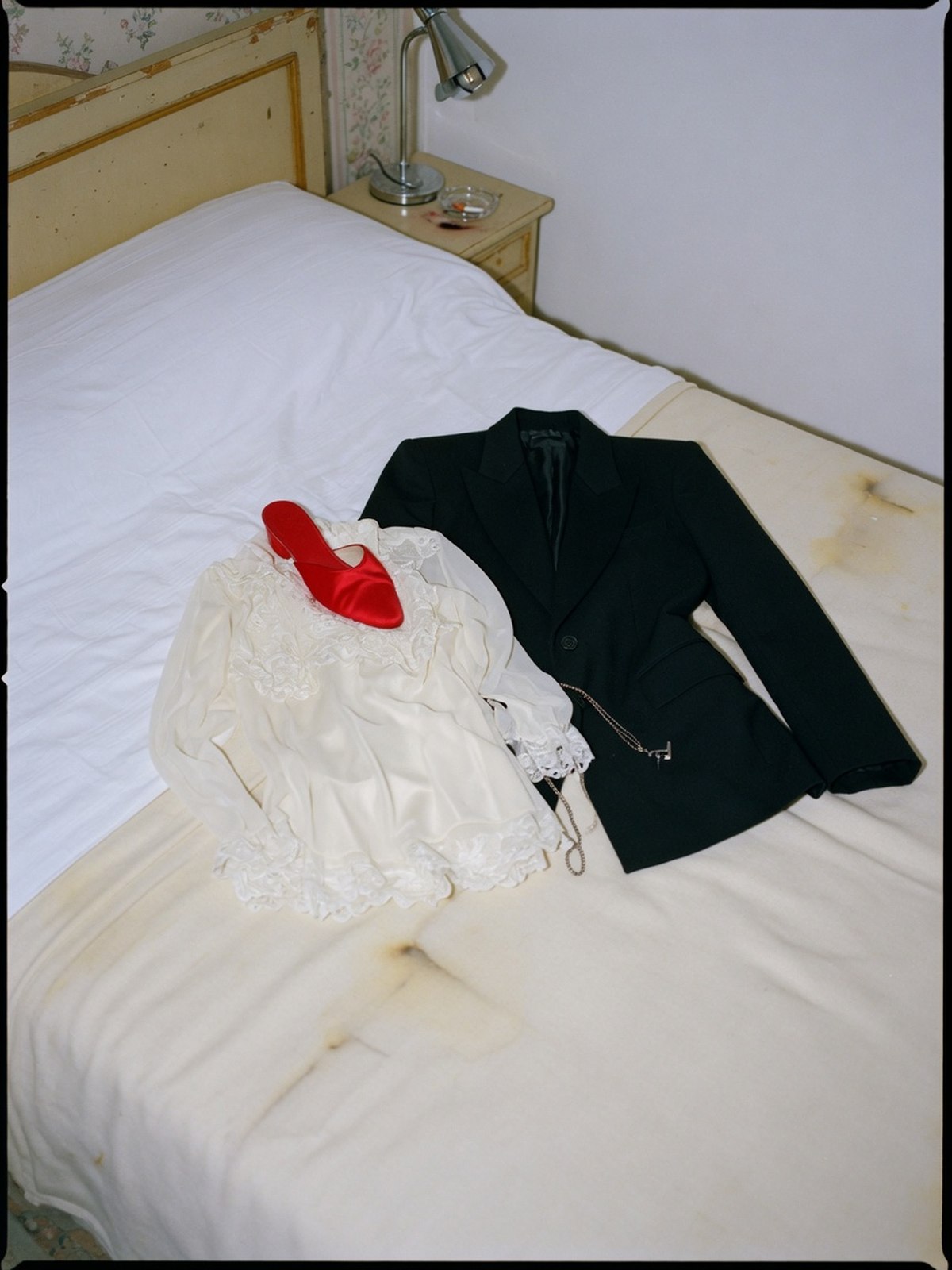 Veste tailoring structurée posée à côté d'un chemisier fluide en dentelle