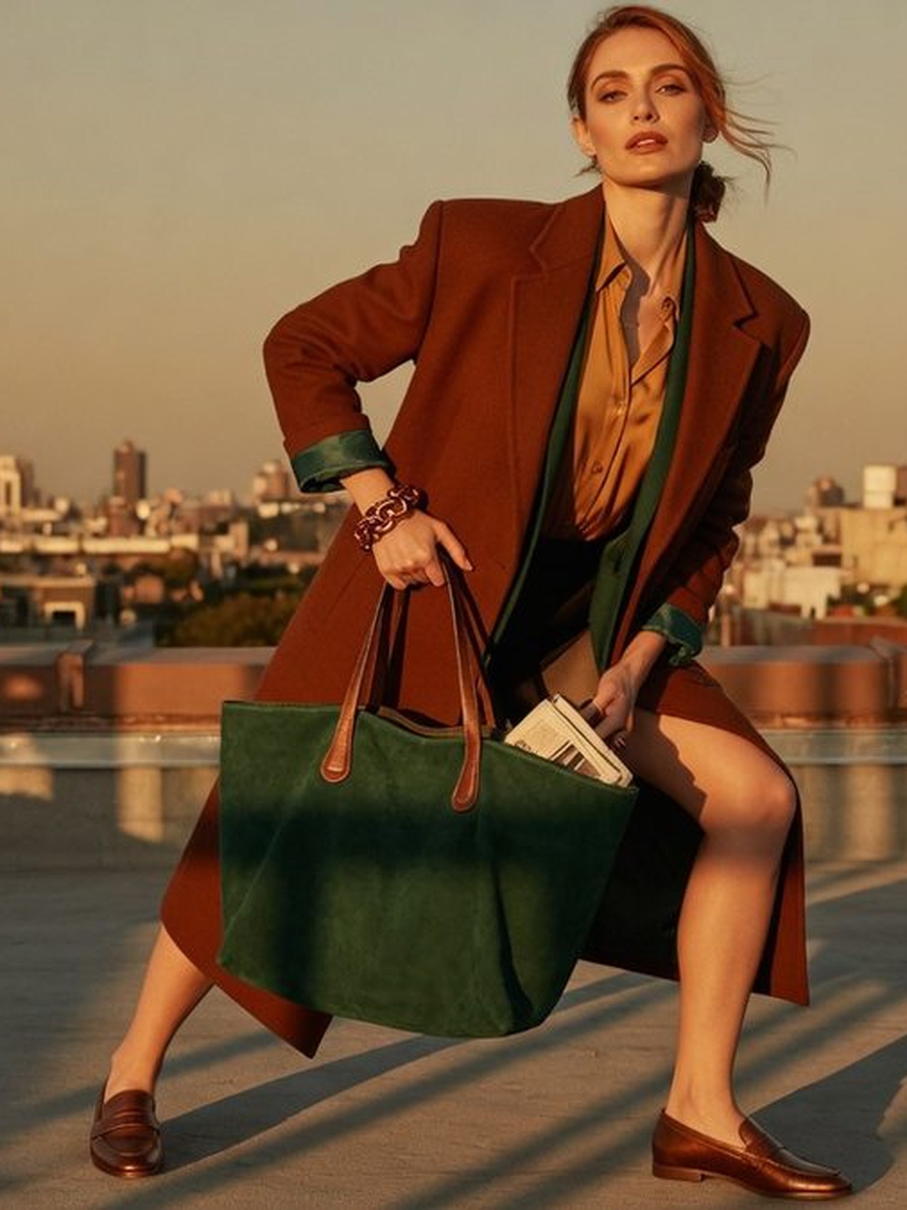 Mannequin portant un tote bag structuré sur l'épaule tout en tenant téléphone et lunettes dans l'autre main, geste du girl grip