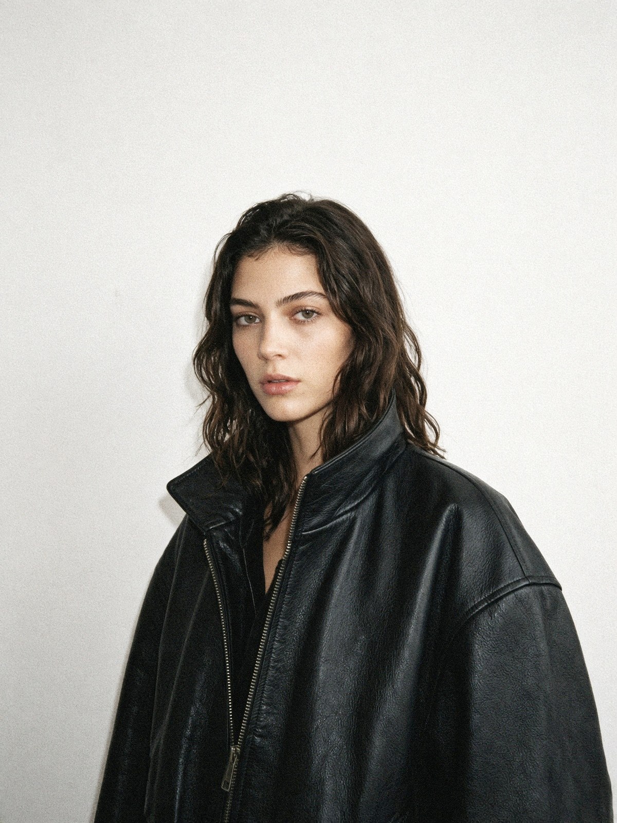 Détail d'une veste en cuir noire oversize portée par un mannequin, épaulement tombant et col structuré visibles