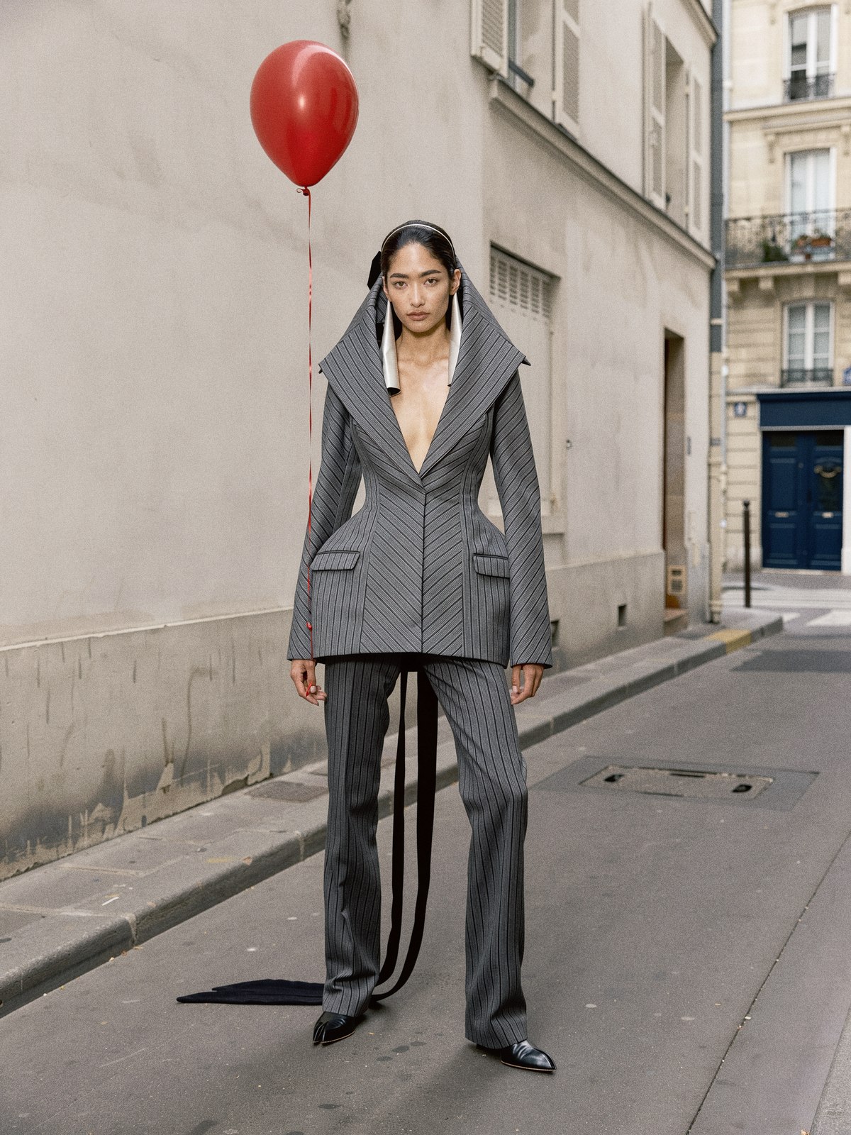 Mannequin portant un pantalon droit uni et la chaussure plate à l'orteil fendu de Jean Paul Gaultier.