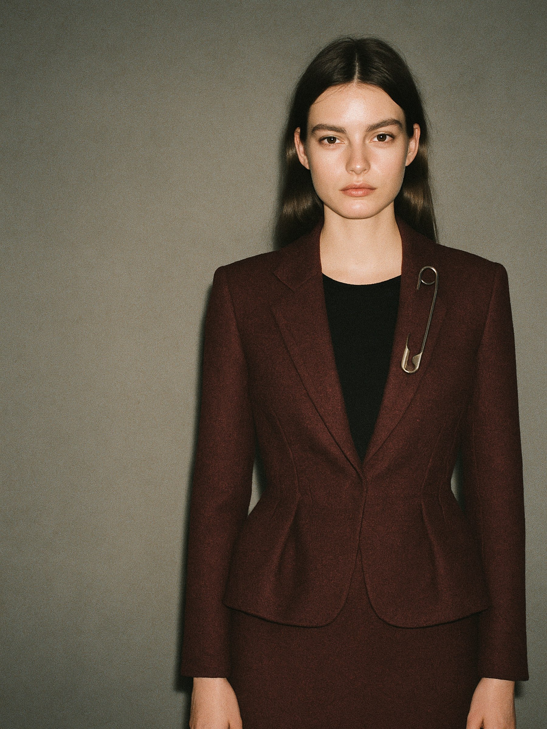 Mannequin de face portant une veste cintrée à effet péplum, silhouette rectangle mise en valeur par la construction du vêtement
