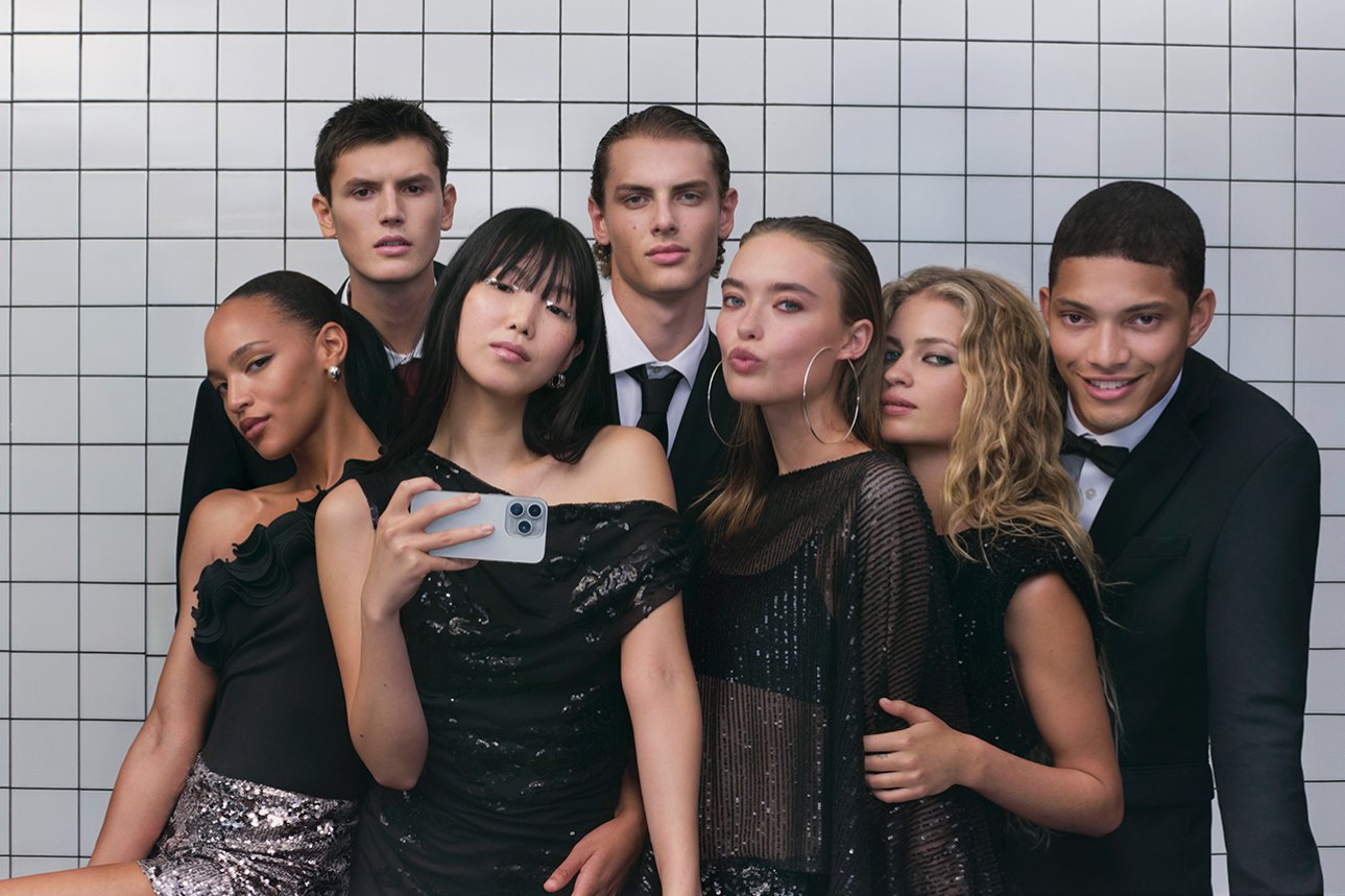Groupe d'invités en tenues noires et à sequins, robes et smokings, devant un mur carrelé blanc, campagne de fêtes Only