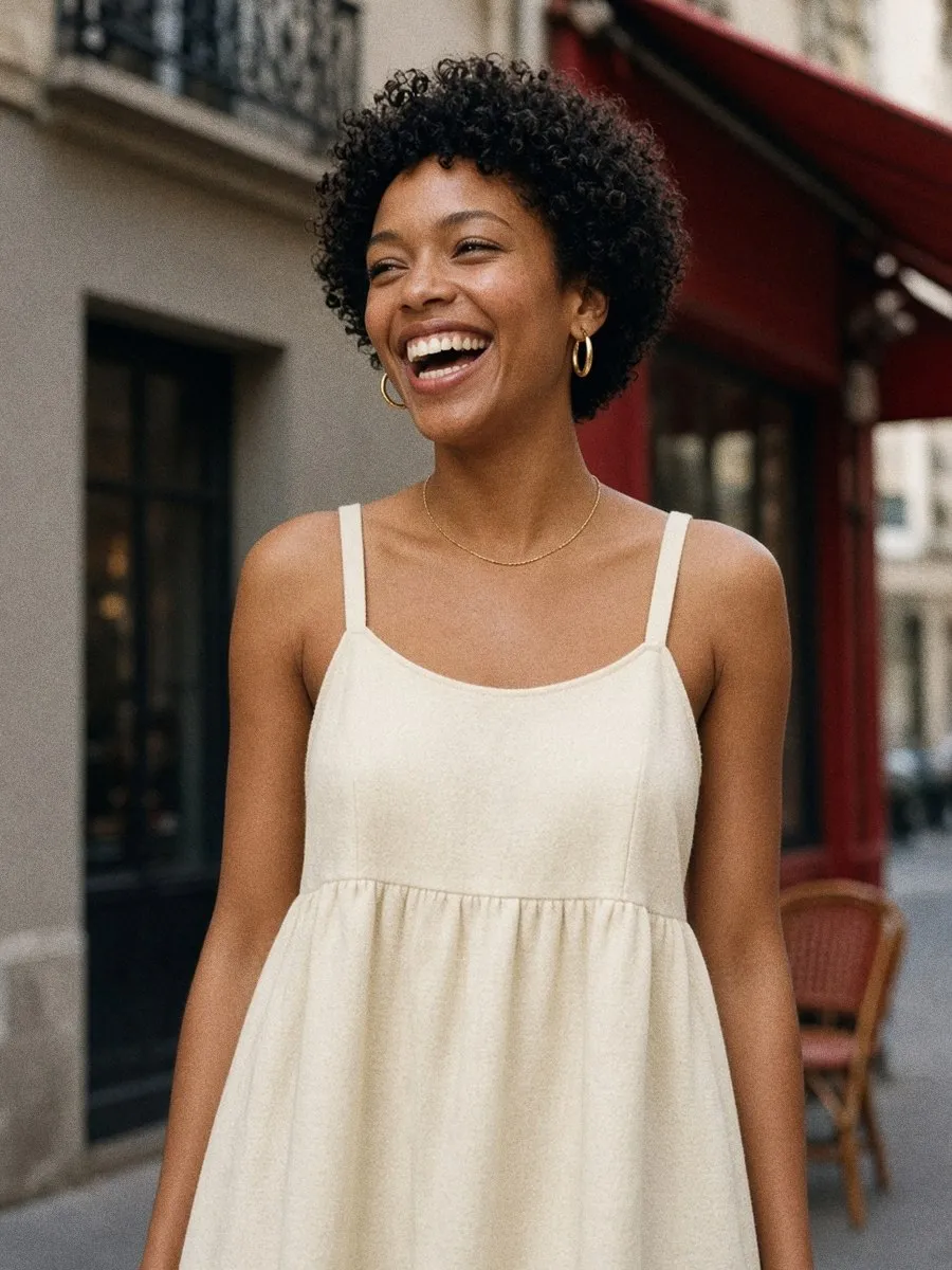 Gros plan sur le haut d'une robe babydoll ivoire avec larges bretelles plates et encolure à biais net