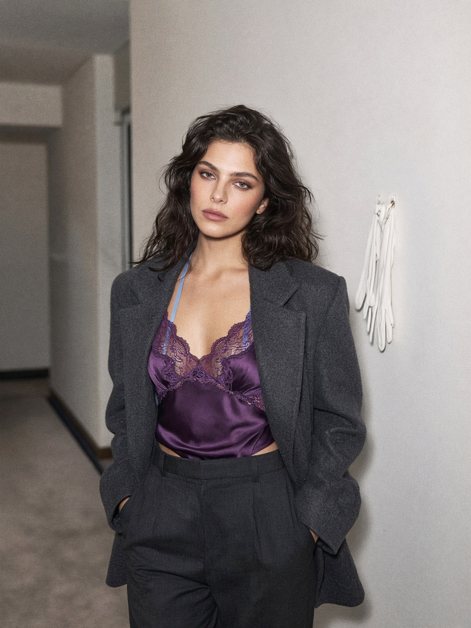 Mannequin en soutien-gorge plongeant en dentelle violette à bretelles bleu clair, sous un blazer ouvert et un pantalon taille haute.